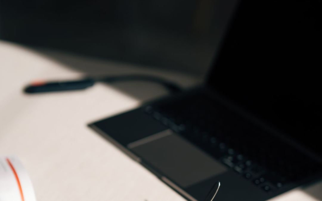 Laptop dan cangkir kopi di atas meja kerja