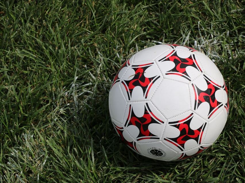 Bola sepak tergeletak di rerumputan lapangan